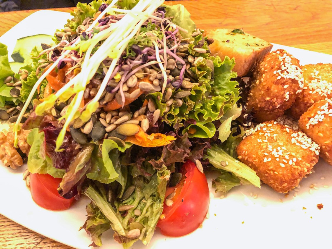 vegetarisches veganes Restaurant: Knuspersalat mit Schafskäsewürfel in Honig-Sesam-Kruste - parkcafè